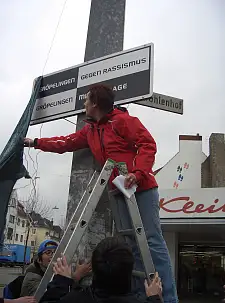 Auf dem Foto sieht man, wie das Schild enthüllt wird