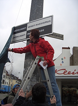 Auf dem Foto sieht man, wie das Schild enthüllt wird