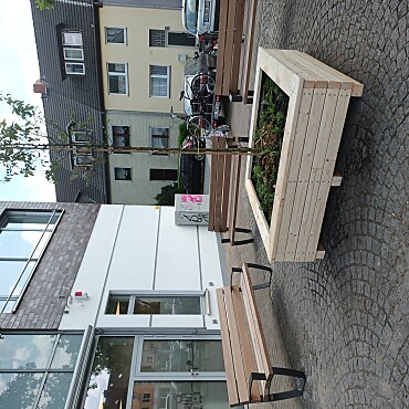 Zusehen ist eine Sitzecke mit drei Bänken um ein Pflanzenbeet auf dem Wartburgpaltz