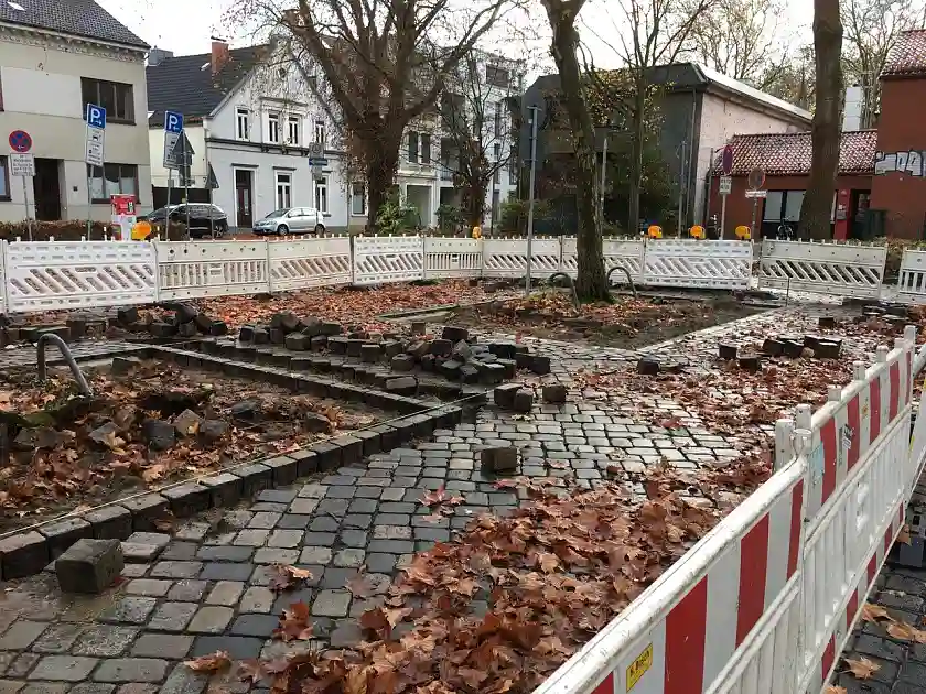 Auf dem Foto ist ein Ausschnitt des Findorffmarktes mit B&auml;umen zu sehen, um die herum die Pflastersteine hoch genommen wurden, um die Baumschieben zu vergr&ouml;&szlig;ern. Es ist ein Teil eines gro&szlig;en Rechtecks um einen Baum zu sehen, wo die Pflastersteine in einem Rahmen neu gesetzt werden.
