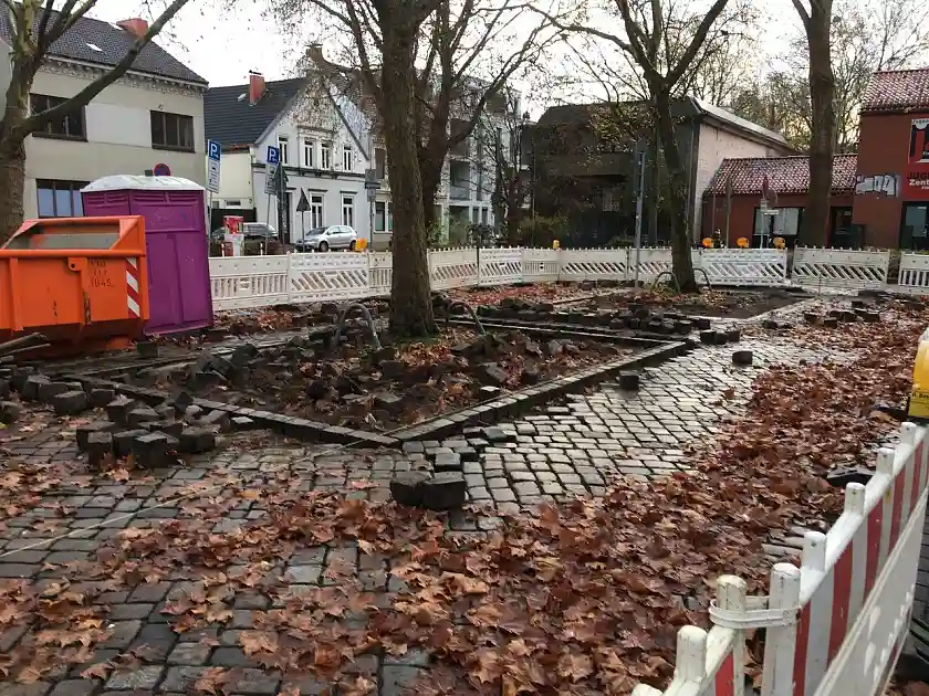 Auf dem Foto ist ein Ausschnitt des Findorffmarktes mit zwei B&auml;umen zu sehen, um die herum die Pflastersteine hoch genommen wurden, um die Baumschieben zu vergr&ouml;&szlig;ern.